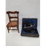 A mid 19th century child/doll chair with a caned seat and a pair of vintage ice skates in a case