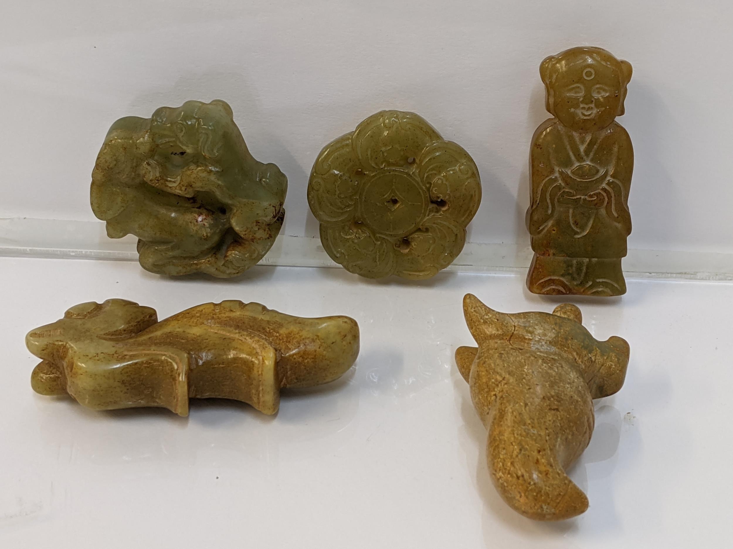 Five Chinese green/brown jade coloured pendants in the form of animals, a figure and others