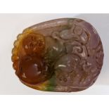 A Chinese pink, green, brown jade pendant carved with a child, fruit and a monkey, 5cm x 4cm