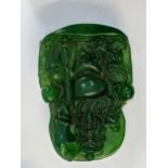 A Chinese green jade pendant carved with an official in a chair, 5cm x 3.8cm