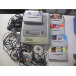 A Super Nintendo game system with two controllers and five games