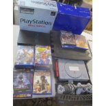 A boxed PlayStation 2 console with mixed games together with two PlayStation 1 consoles, one with