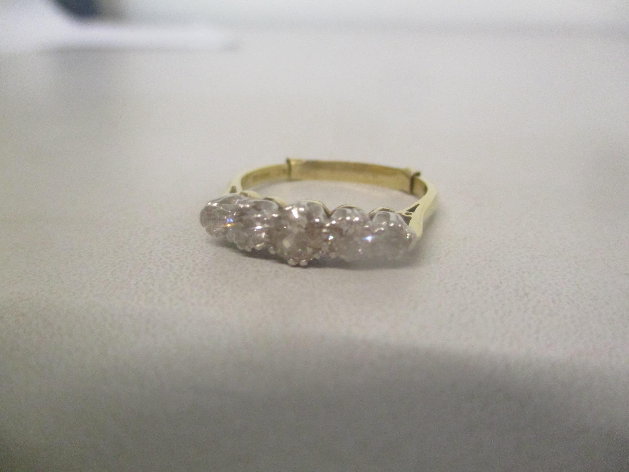 An 18ct gold and platinum ring set with five diamond, the centre stone chipped, 4g