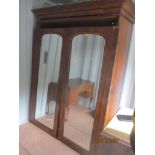 A Victorian burr walnut veneered two door wardrobe having two mirrored doors, revealing filled