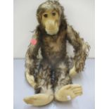 A vintage brown felt and faux fur monkey soft toy with movable arms, head and legs, straw filled