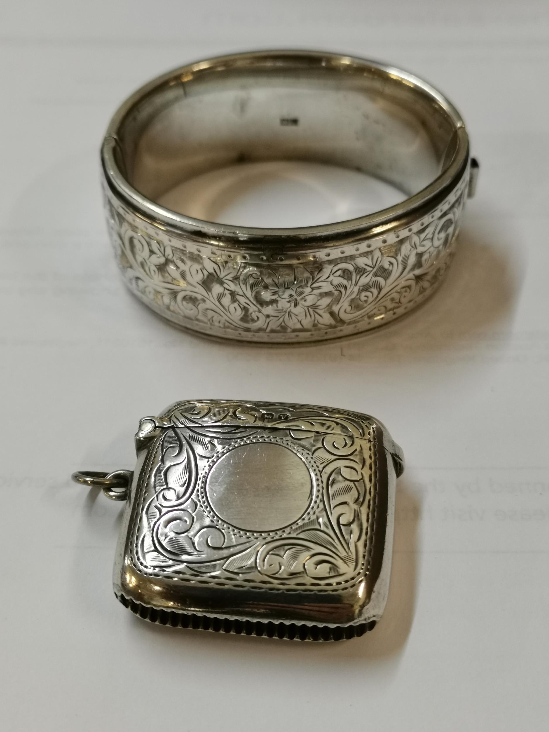 An early 20th century silver vesta case and a silver bangle Location: Cab