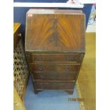 A reproduction mahogany bureau of narrow proportions, fall flap revealing a fitted pigeon hole