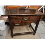 A late 18th/early 19th century oak side table with single drawers above shaped apron, raised on