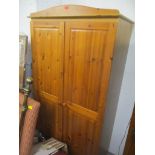 A modern pine two door wardrobe, on a bracket plinth, 183cm h x 93cm w, and a matching three