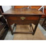 A late 18th/early 19th century oak side table with single drawer above shaped apron, raised on