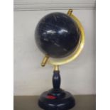 A blue gemstone globe with gold coloured mount on a blue base, where each country is represented