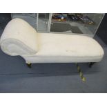 A Victorian chaise longue upholstered in cream fabric, on turned tapered walnut legs and castors