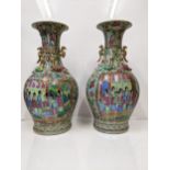 A pair of 19th century Canton porcelain vases of baluster form decorated with panels of ladies on