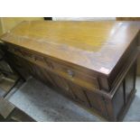 A modern oak sideboard with three drawers and three carved panelled doors, and a matching bookcase