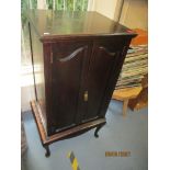 An Edwardian mahogany music cabinet with twin panelled doors, on cabriole legs