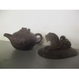 A 20th century Chinese Yixing Zisha pottery teapot and an Indian carved wooden model lion on a