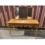 A Gordon Russell 1950s walnut and beech dressing table having a triptych mirror, central sliding