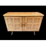 A mid century Ercol light elm sideboard, with two carved doors enclosing two drawers and shelf