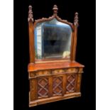 A Victorian walnut Gothic style mirrored backed sideboard, the mirror supported by two carved
