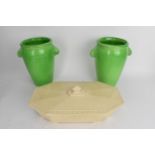 A pair of Ashstead pottery green glazed vases decorated with fish handles and numbered V77 to the