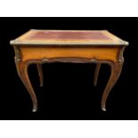 A 19th century French Louis XV style mixed veneer writing table having a red leather topped scriber,