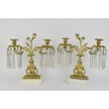 A pair of late 19th century continental gilt metal candelabra, each with twin scrolled, floral