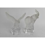 Two Goebel frosted glass paperweights raised on octagonal formed bases to include one in the form of