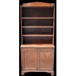 A Regency mahogany bookcase with arched pediment top, above adjustable shelves and tow cupboard