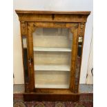 A large Victorian walnut pier cabinet with gilt metal mounts, a curved frieze, a glazed door,