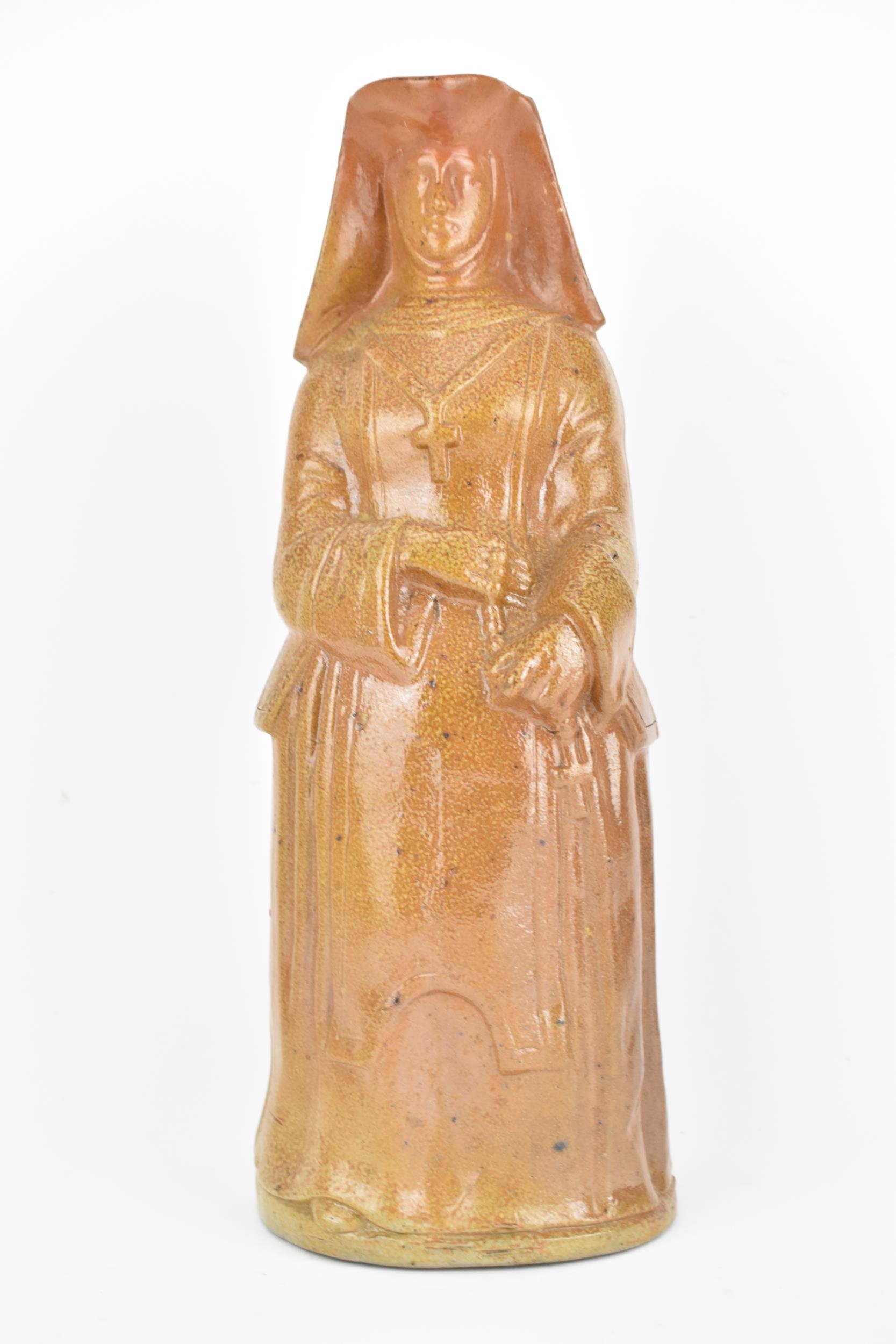 A 19th century salt glaze stoneware jug fashioned as a nun holding rosary beads, 36cm high,
