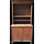 A Regency mahogany bookcase with adjustable shelves above two cupboard doors and reeded borders,