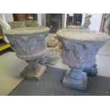 Two stoneware garden planters in the form of urns decorated with grape vines and raised on square