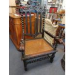 A large Victorian carved oak armchair with barley twist supports and stretchers and caned seat