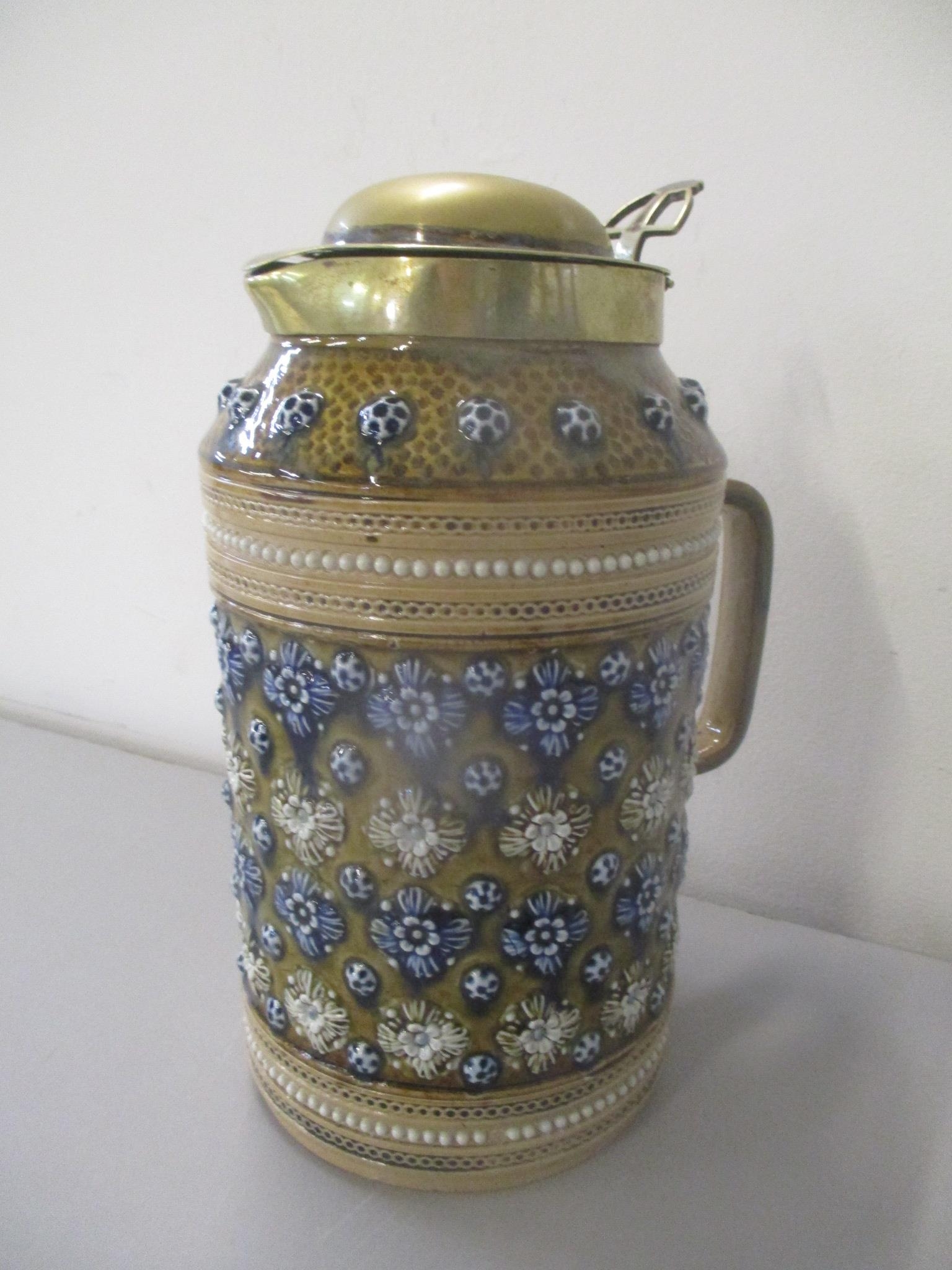 A Doulton Lambeth stoneware jug having a brass lid and decorated with raised floral detail, numbered - Image 2 of 3