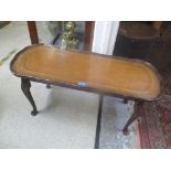 A late 20th century mahogany coffee table with a brown leather top