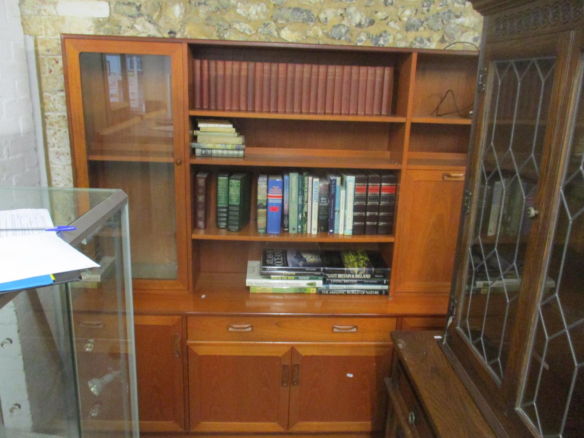 A mid-century G-Plan teak display cabinet having open shelves, cocktail cabinet, glazed door with