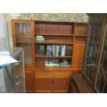 A mid-century G-Plan teak display cabinet having open shelves, cocktail cabinet, glazed door with