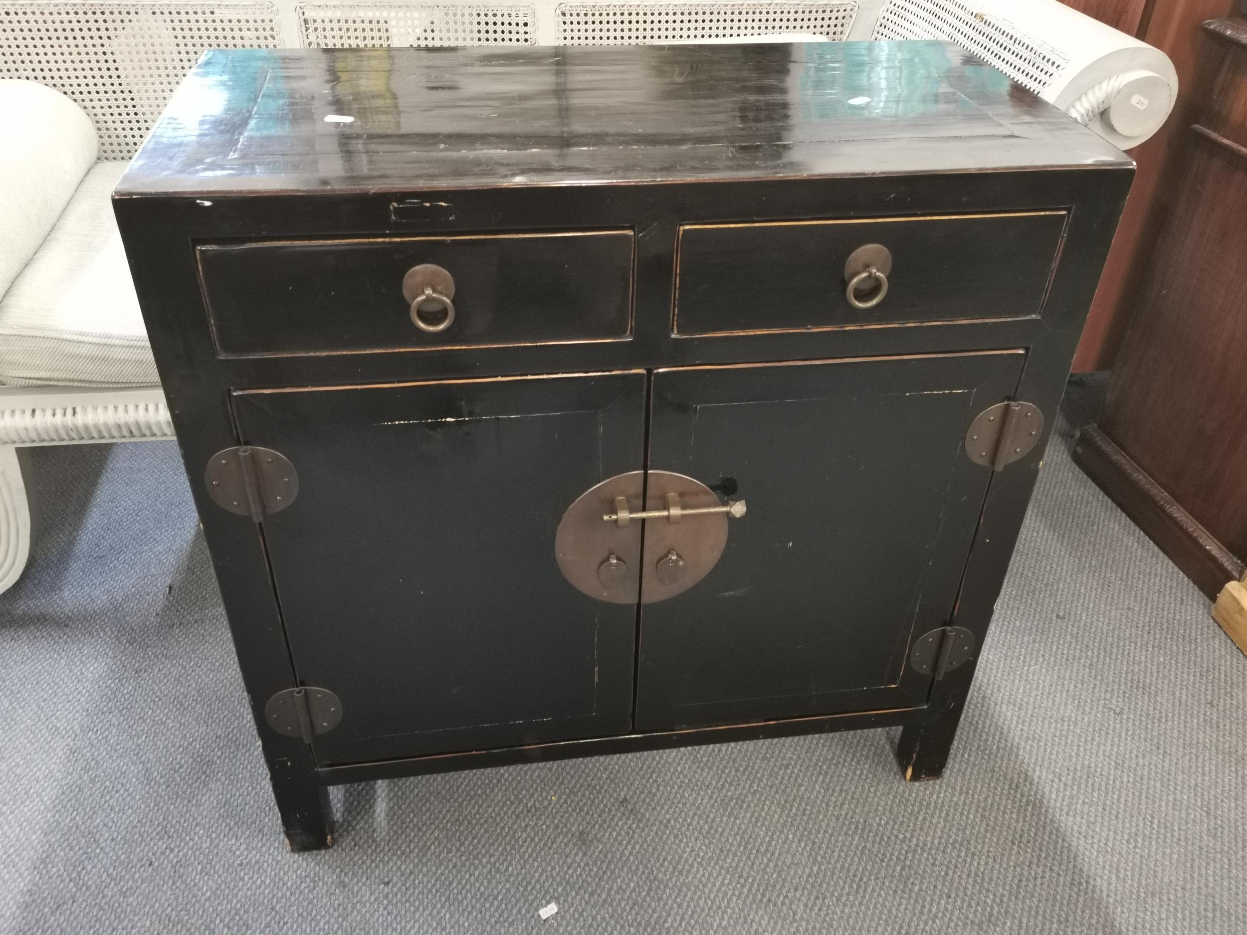 A 20th century Chinese black lacquered side cabinet, with two drawers over two cupboard doors, 85