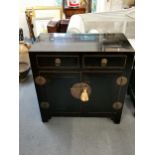 A 20th century Chinese black lacquered side cabinet, with two drawers over two cupboard doors, 83