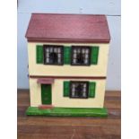 A Triang Toys dolls house with a wooden roof and paper clad walls, with furniture, 42cm h x 33cm w