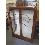An Art Deco walnut veneered display cabinet having twin glazed doors and two loose glass shelves,