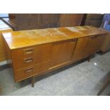 A mid 20th century retro teak sideboard having three drawers, one pull-down door and two sliding