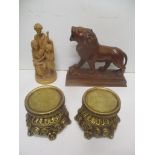A carved wooden group and a model of a lion along with two gilt stands