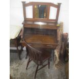 An early 20th century oak roll top desk of small proportions with a tambour front over a shelf,