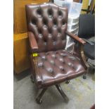 A reproduction leather button and stud back swivel office armchair
