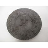 A cast and patinated Elkington style bronze dish decorated with masks and scrolled foliage, 15cm dia