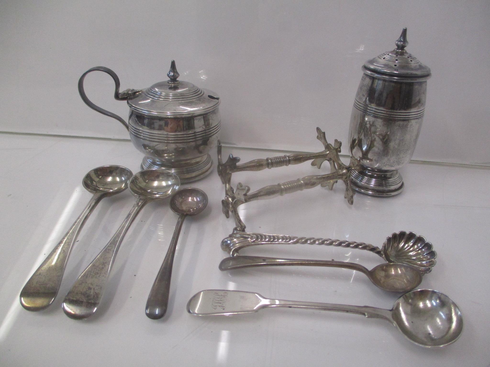 Silver condiments to include a pepper and a mustard, three mustard spoons, three salt spoons and a