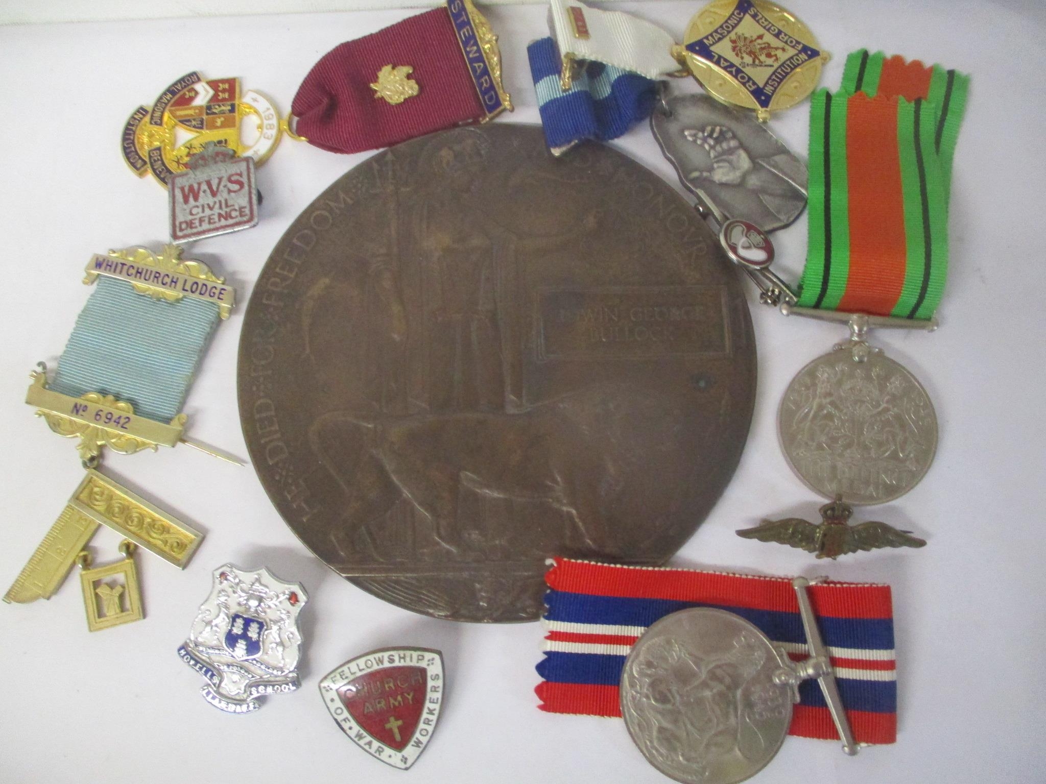 A selection of medals and badges to include a death plaque named Edwin George Bullock, Defence and