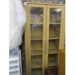 A modern light oak two door glazed bookcase having four fitted shelves, 190cm h x 90cm w