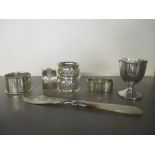 A group of silver items to include a set of three Edwardian napkin rings, Chester 1903, a